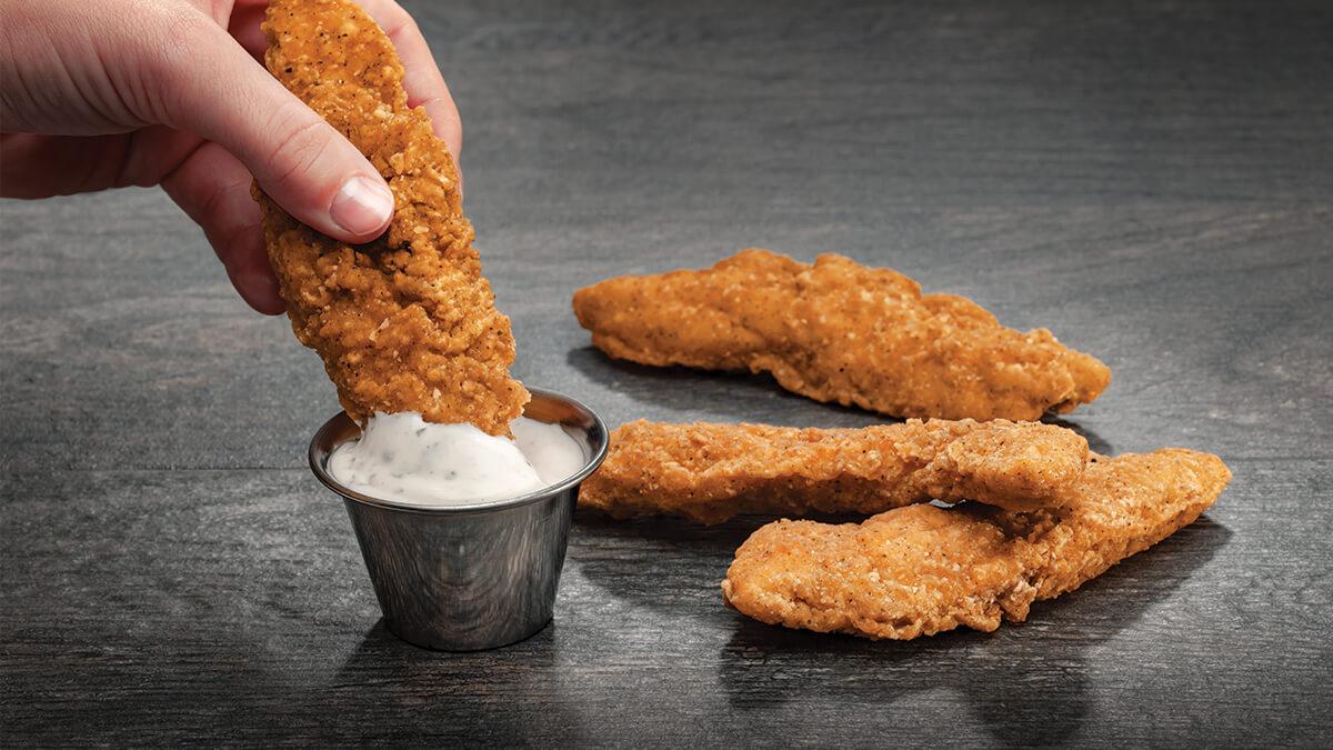 Dipping chicken strips in ranch